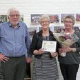 Formanden for Thorsø Håndværker- og Borgerforening, Hans Dahlgaard, overrækker Thorsø-Rosen til butiksleder Nancy Bertelsen og Bente Henriksen.