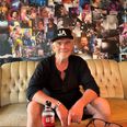 46 års festivalliv hænger på væggene bag JP Andersen. Her er han i sofaen i den gamle »førerbunker«, hvor tusindvis af fotos fortæller historien om artister, medhjælpere og et langt liv med Smukfest. Foto: Grethe Bo Madsen