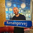 Den nye kunstneriske leder af Favrskov Korfestival, Phillip Eick fra Aarhus, står med et af de to vejskilte, der for nylig blev sat op i Voldby ved Hammel. De blev dog hurtigt pillet ned igen, for der skulle stå Korsagervej og ikke Korsangervej. Det forkerte vejskilt er siden kommet i den lokale korfestivals varetægt. Pressefoto