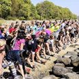 Hundredvis af mennesker træner med udsigt over havet. Kvinden i forgrunden har fået spraymalet Sick Projects logo på t-shirten. Et tilbud alle får. Foto: Mads Johansen - madsfoto.dk