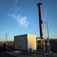 AgroGas anlægget opsamler metan, som siver op gennem jorden på lossepladsen. Metangassen afbrændes i den flere meter høje gasfakkel og omdannes til CO2. Derved reduceres klimabelastningen til en brøkdel, idet metan er en drivhusgas med klimapåvirkning, der er 28 gange stærkere end CO2. Foto: Favrskov Forsyning.
