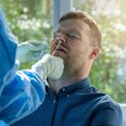 coronavirus nasal swab test - lab worker taking a mucus sample from male patient nose