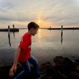 Få minutter over klokken 20, hvor dette foto er taget, kulminerede den delvise solformøkelse, men nogen havde mere travlt med at springe fra sten til sten ved havneindløbet end at se mod solen. Drengen her får chancen igen i 2048. Foto: Afh