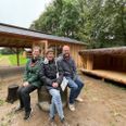 Fra venstre Lene Mørk Jensen, Merete Baastrup og Thure Lyhne glæder sig over Hammel-spejdernes nye bålhytte i baggrunden og tre sheltere, hvoraf man kan se det ene på billedet. Foto: Jeppe Rafn