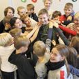 Johan Høyer omgivet af et hav af udstrakte arme og hænder fra sine klassekammerater, som har været en stor støtte for den 12-årige dreng under et langvarigt sygdomsforløb.