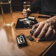 Man takes car keys after using cocaine drug and drinking whiskey. Drugs and alcohol, danger drunk driving concept