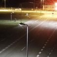 Den lyse personbil ses passere lyskrydset øverst i billedet. Den formodes at have skader på fronten og eventuelt en knust rude. Overvågningsfoto: Midt- og Vestjyllands Politi