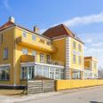 Den store gule hotelbygning tæt ved å, havn og strand er på nye hænder. Foto: Nordicals