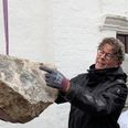 Kvaderstenen løftes ned fra kirketårnet og tages imod af fagfolk. Foto: Folkekirken i Aarhus