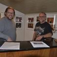 Allan Nordestgaard Sørensen og Jesper Land Gregersen foran nogle få af en lang række billeder fra musik- og fest-aftener i Røgen Forsamlingshus. Foto: Anette Bonde.