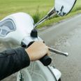Riding scooter on rural road. Hand on the throttle grip