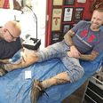 Denne gang var det sidste vers af salmen ’Hil dig, Frelser og Forsoner’, som Ronni Froberg fra Hr og Fru Tattoo forevigede på Peter Sporleders skinneben.