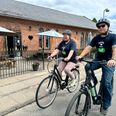 Cafémedarbejder Sabina Hvid og pædagogstuderende Jesper Vallø er hoppet på et par af de nyindkøbte elcykler i Café Grenaa. Håbet er, at elcyklerne kan være med til at skabe en bro for flere af caféen gæster fra ensomhed til en mere social hverdag. Foto: Simon Carlson