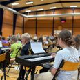 Omkring 100 skoleelever indtog Pavillonens store hal med guitarer, klaverer, ukuleler, trompeter og trækbasuner og spillede koncert. Pressefoto