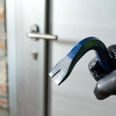 Thief with a bar of iron in the hand to open a door