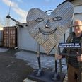 »I samarbejdets ånd knytter vi alle bånd«, står der på det skilt, der følger med Ole Melin-Nielsens værk til Corona Camping ved Køge. Foto: Anette Bonde.